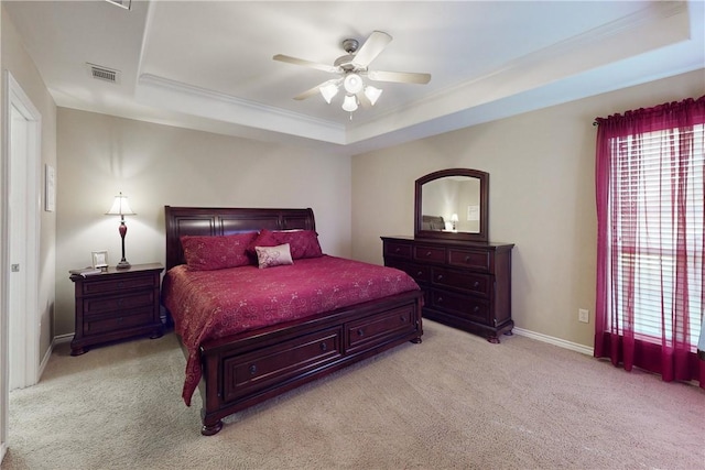 bedroom featuring crown molding, light colored carpet, a raised ceiling, and ceiling fan