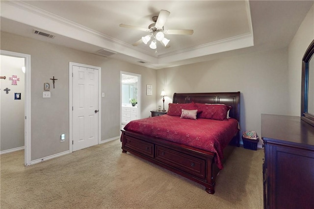 bedroom featuring crown molding, ceiling fan, connected bathroom, a tray ceiling, and light colored carpet