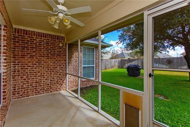 unfurnished sunroom with ceiling fan