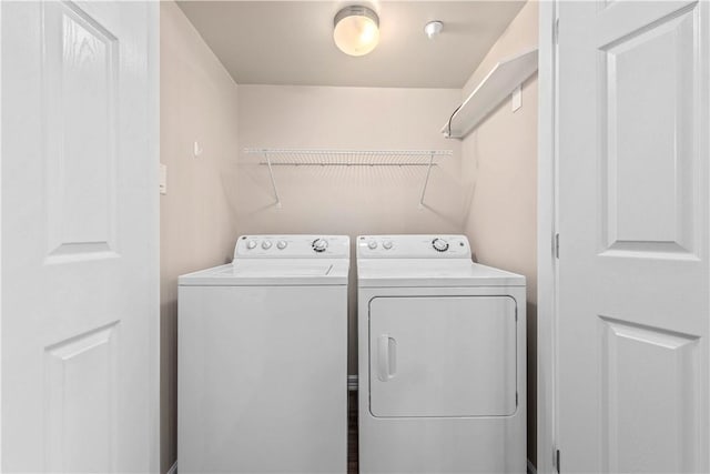 clothes washing area with washing machine and dryer