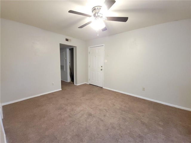 unfurnished room with ceiling fan and carpet