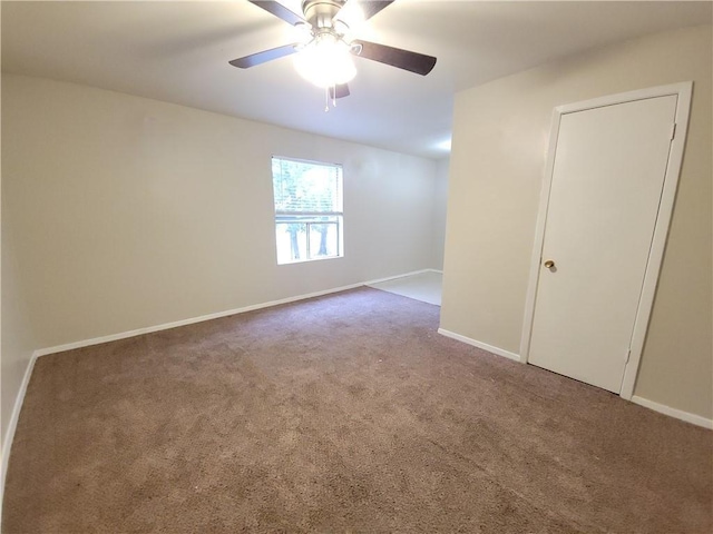 empty room featuring ceiling fan and carpet