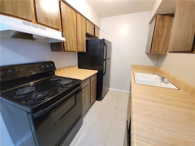 kitchen featuring black appliances, light tile patterned floors, and sink