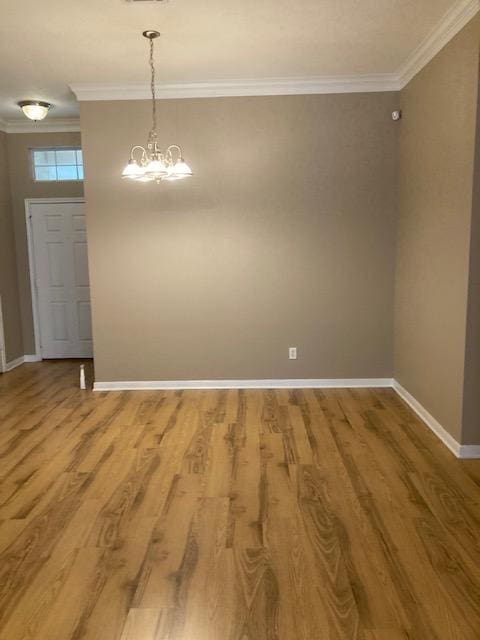 2704 Barronwood Dr, Bryan, TX 77807 - spare room with crown molding, baseboards, wood finished floors, and a chandelier