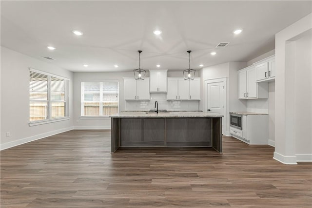 881 Double Mountain Rd, College Station, TX 77845 - kitchen with white cabinets, recessed lighting, baseboards, backsplash, and dark wood-style floors