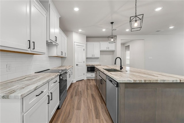 881 Double Mountain Rd, College Station, TX 77845 - kitchen featuring appliances with stainless steel finishes, a sink, dark wood-style flooring, recessed lighting, and a kitchen island with sink