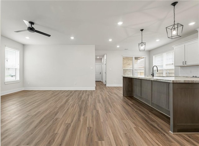 881 Double Mountain Rd, College Station, TX 77845 - kitchen with baseboards, recessed lighting, healthy amount of natural light, light wood-style floors, and white cabinets