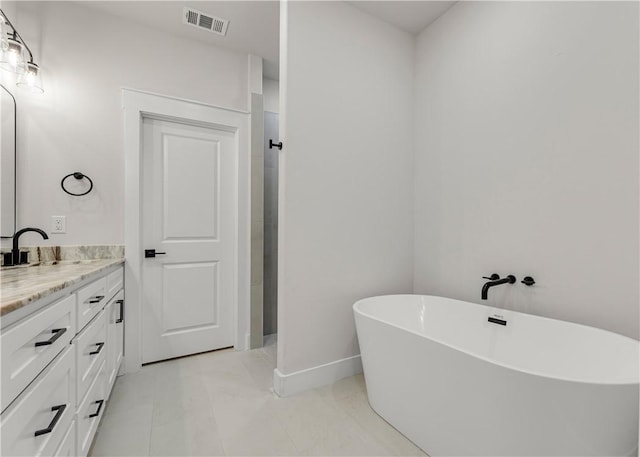 881 Double Mountain Rd, College Station, TX 77845 - bathroom featuring vanity, a freestanding tub, and baseboards