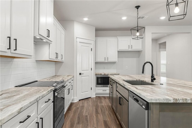 881 Double Mountain Rd, College Station, TX 77845 - kitchen with appliances with stainless steel finishes, a sink, dark wood-style flooring, white cabinetry, and a center island with sink