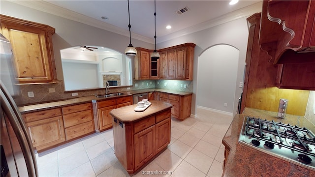 kitchen featuring stainless steel appliances, ceiling fan, sink, pendant lighting, and a kitchen island