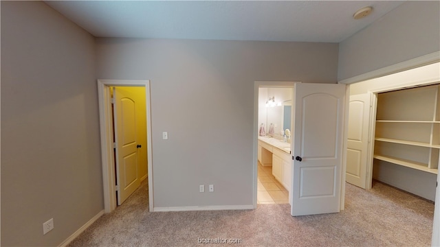 unfurnished bedroom with light carpet and ensuite bath