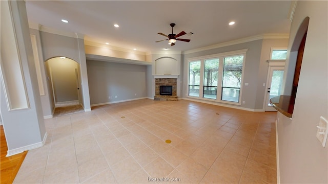 unfurnished living room with a fireplace, ceiling fan, crown molding, and light tile patterned flooring