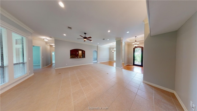 unfurnished living room with ceiling fan with notable chandelier, light tile patterned floors, and crown molding