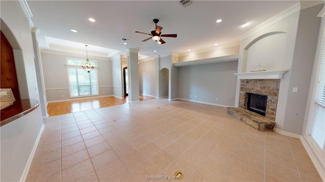 unfurnished living room featuring ceiling fan with notable chandelier, light tile patterned flooring, ornamental molding, and a fireplace