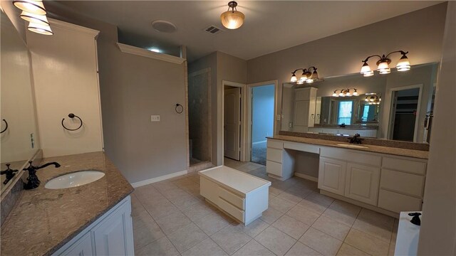 bathroom featuring tile patterned floors, two vanities, and a walk in shower