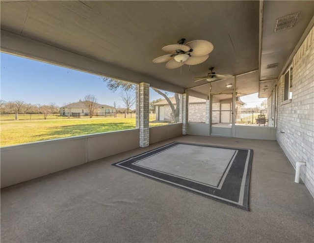 unfurnished sunroom with a ceiling fan and visible vents