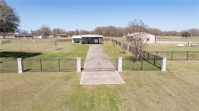 view of yard featuring a carport, a rural view, a gate, and fence