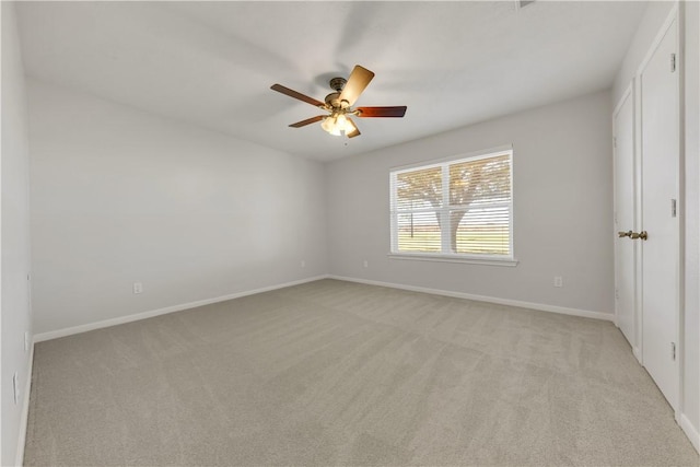 unfurnished room featuring light carpet, baseboards, and ceiling fan