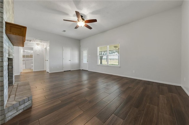 unfurnished living room with baseboards, a fireplace, ceiling fan, and dark wood-style flooring