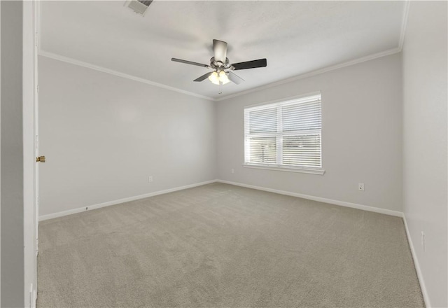 empty room with visible vents, carpet flooring, crown molding, and baseboards