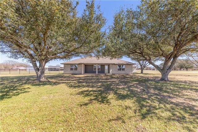 ranch-style house featuring a front lawn and fence