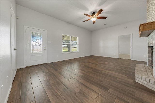 unfurnished living room with a fireplace, baseboards, a ceiling fan, and dark wood-style flooring