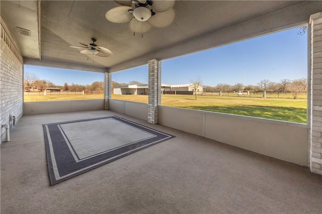 unfurnished sunroom featuring plenty of natural light and a ceiling fan