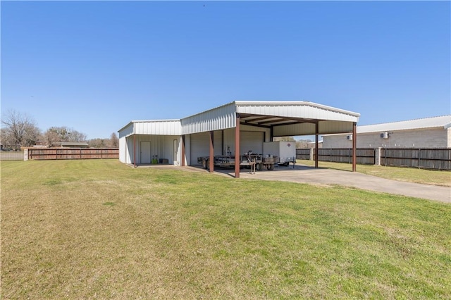 rear view of house featuring a yard, fence, and a garage