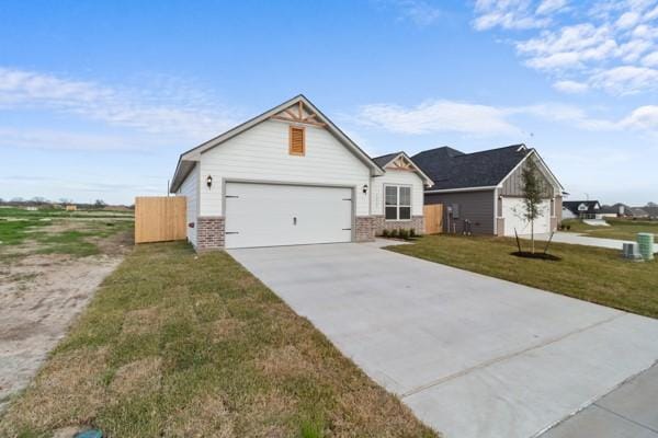 modern farmhouse featuring a garage, concrete driveway, a front lawn, and brick siding