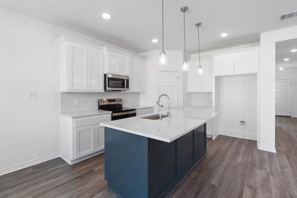 kitchen featuring visible vents, dark wood finished floors, a sink, white cabinets, and stainless steel appliances