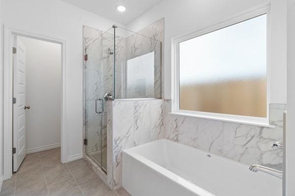 full bath featuring a garden tub, a marble finish shower, and tile patterned floors