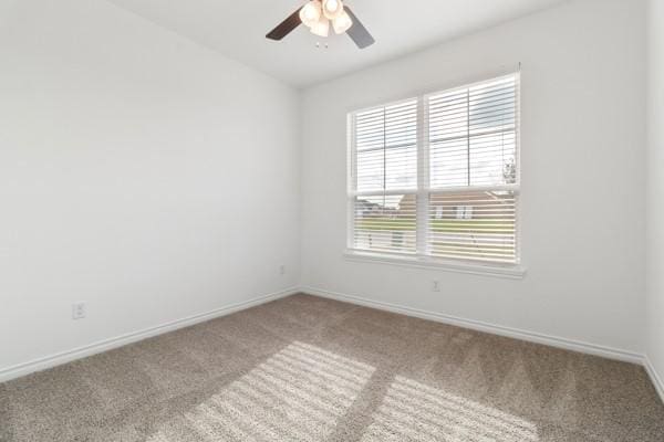 carpeted spare room with baseboards and ceiling fan
