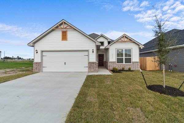 craftsman-style home with brick siding, a garage, a front lawn, and concrete driveway