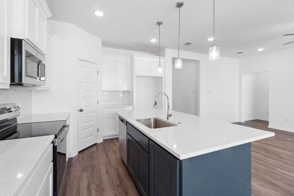kitchen with a sink, white cabinetry, dark wood-style floors, and stainless steel appliances