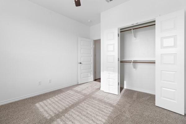 unfurnished bedroom with a closet, carpet flooring, and baseboards
