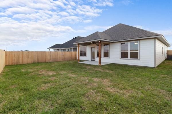 rear view of property with a lawn, a patio, and a fenced backyard