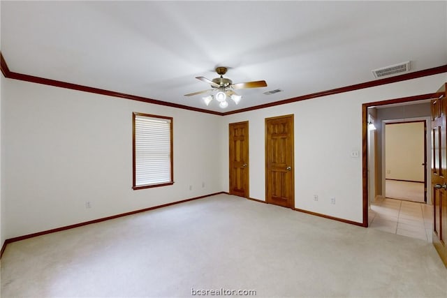 unfurnished bedroom featuring multiple closets, light carpet, ceiling fan, and ornamental molding