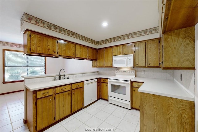 kitchen with kitchen peninsula, white appliances, light tile patterned flooring, and sink