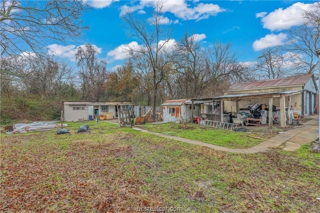 rear view of house with a yard and an outbuilding