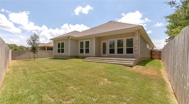 rear view of property featuring a yard