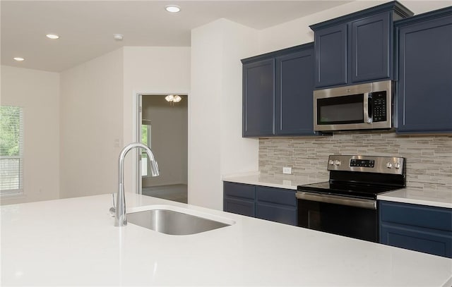 kitchen with sink, blue cabinetry, appliances with stainless steel finishes, and decorative backsplash