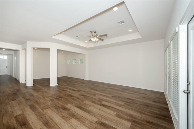 interior space featuring ceiling fan, dark hardwood / wood-style floors, and a tray ceiling