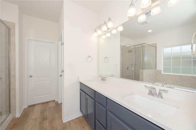 bathroom featuring wood-type flooring, walk in shower, and vanity