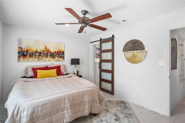 bedroom featuring a barn door and ceiling fan