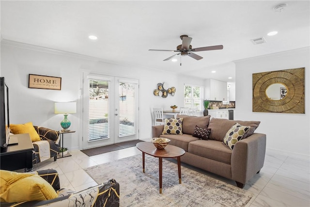 living room with ceiling fan, crown molding, a wealth of natural light, and french doors