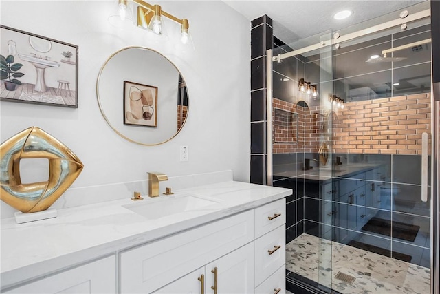 bathroom with vanity and a shower with shower door