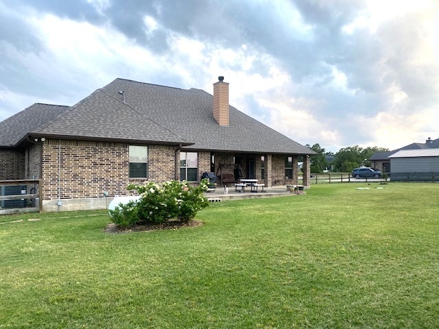 7585 Field Creek Estates Dr, Bryan, TX 77808 - rear view of property featuring brick siding, a patio area, a chimney, and roof with shingles