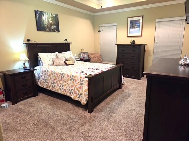 7585 Field Creek Estates Dr, Bryan, TX 77808 - bedroom with light colored carpet, ornamental molding, and a tray ceiling
