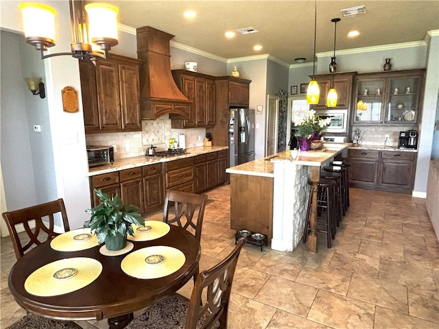 7585 Field Creek Estates Dr, Bryan, TX 77808 - kitchen featuring appliances with stainless steel finishes, premium range hood, tasteful backsplash, light countertops, and a center island