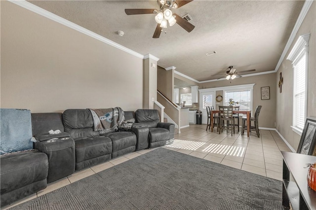 living room featuring light tile patterned floors, a textured ceiling, ceiling fan, and crown molding